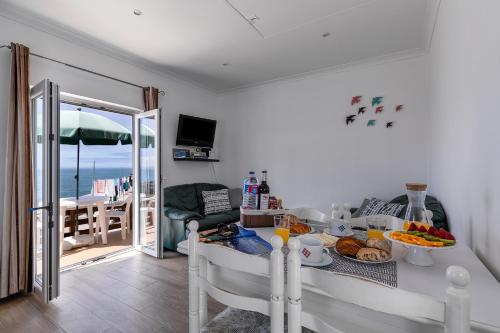 uma cozinha com uma mesa com comida e vista para o oceano em CASA DA FALÉSIA 28 - Casa em Peniche
