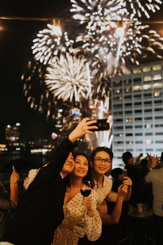 a group of people taking a picture of fireworks at Hotel Once Bangkok in Bangkok