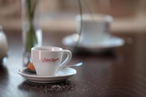 a coffee cup on a plate on a table at Lieblingsplatz Hotel Strandperle in Travemünde