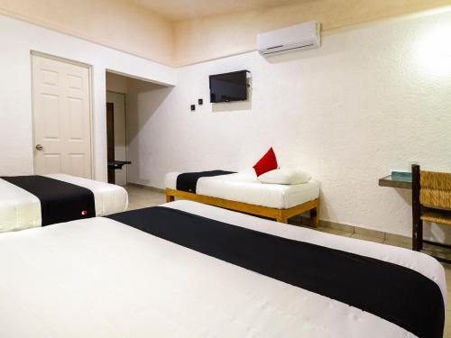 a hotel room with two beds and a tv at Hotel Parotas Manzanillo in Manzanillo