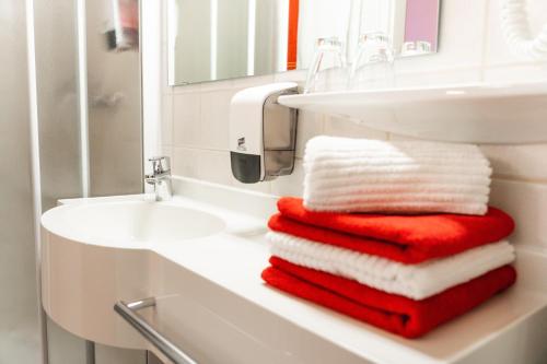 a bathroom with red and white towels on a sink at Pension Waldfriede in Bad Tatzmannsdorf