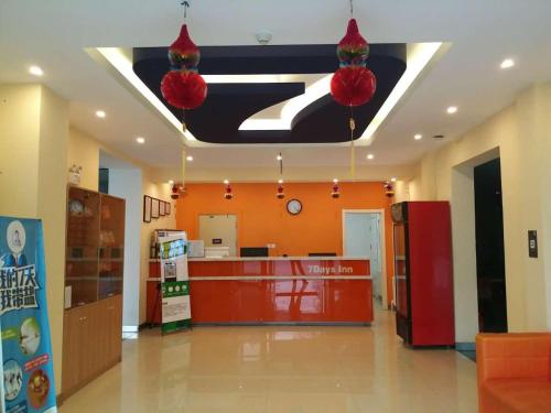 un vestíbulo de una tienda con paredes de color naranja y un mostrador en 7Days Inn Harbin Pioneer Road Xilong Market en Harbin