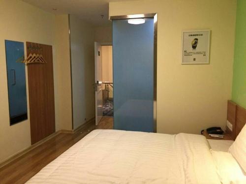 a bedroom with a bed and a blue door at 7Days Inn Yingshang LAN-STAR building materials market in Fuyang