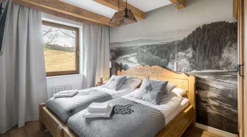 a bedroom with two beds and a painting on the wall at Limba - Ostoja Bukowinki in Jaworki