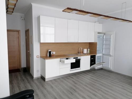 una cocina con encimeras blancas y armarios blancos en Palm apartment studio Riga, en Riga