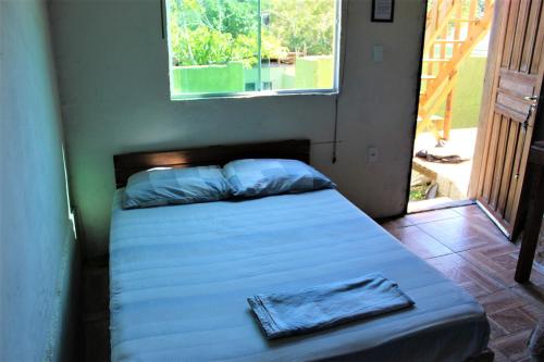 a bed in a room with a window and a bed sidx sidx sidx at Magic Island Casas in Florianópolis