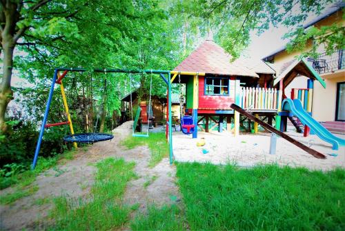 um parque infantil em frente a uma casa com baloiços em Pokoje z widokiem na morze 2 em Jastarnia