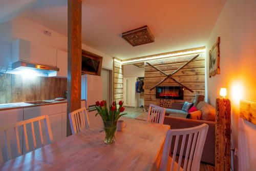 a kitchen and dining room with a wooden table and chairs at Apartamenty u Gąsieniców Zakopane in Zakopane