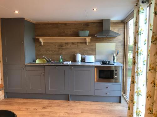 a kitchen with a sink and a stove at Orchard Glamping in Catterall