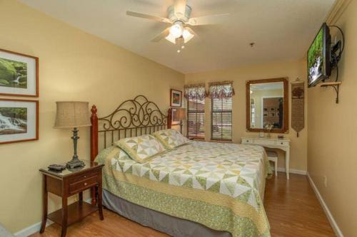 a bedroom with a bed and a ceiling fan at Across from Dollywood w FREE Dollywood ticket, pets ok wfee, arcade, hot tub in Pigeon Forge