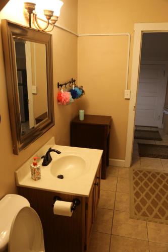 y baño con lavabo, espejo y aseo. en Charming 2BD near UC, Hospitals,ZOO, en Cincinnati