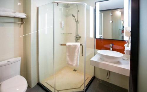 a bathroom with a glass shower and a sink at 7Days Premium Tangshan Fengnan Shuang Lake Jinyuan in Tangshan