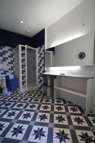 cocina con azulejos azules y blancos en el suelo en Mas Manyaques, en Le Tech