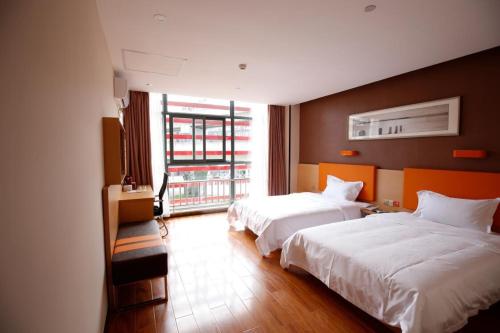 una camera d'albergo con due letti e una grande finestra di 7Days Premium Chengdu Dufu Thatched Cottage a Chengdu