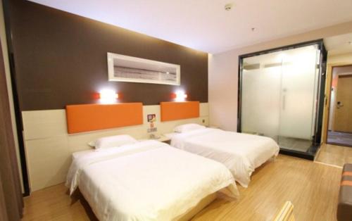 a hotel room with two beds and a window at 7Days Premium Yunfu Xinxing Bus Station in Yunfu