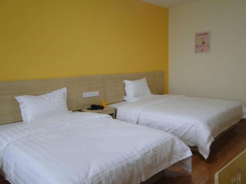 dwa łóżka siedzące obok siebie w pokoju w obiekcie 7Days Inn Taihe Guoxing Auto and Agricultural Machine City w Ji'an