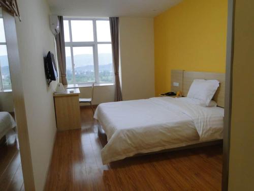 pokój hotelowy z łóżkiem i oknem w obiekcie 7Days Inn Taihe Guoxing Auto and Agricultural Machine City w Ji'an