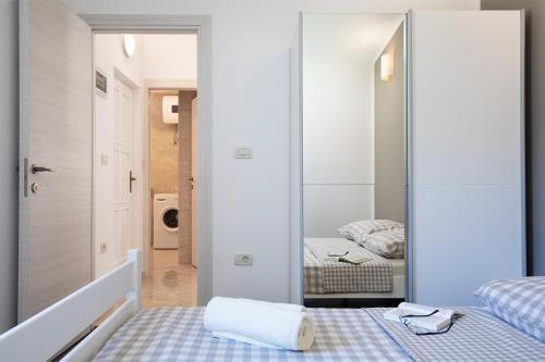 ein Schlafzimmer mit einem Spiegel und einem Bett in der Unterkunft Sandy Bay Apartments - free mountainbike rental - in Pješčana Uvala