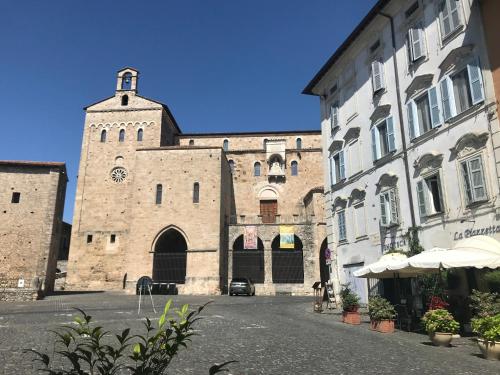 duży kamienny budynek z wieżą zegarową w obiekcie La Piazzetta Affittacamere Ristorante w mieście Anagni