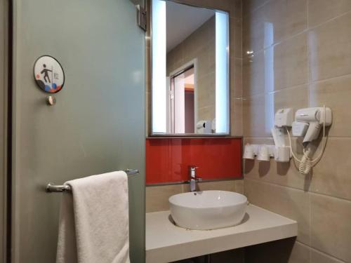 a bathroom with a sink and a mirror at 7Days Premium Dalian Airport in Dalian