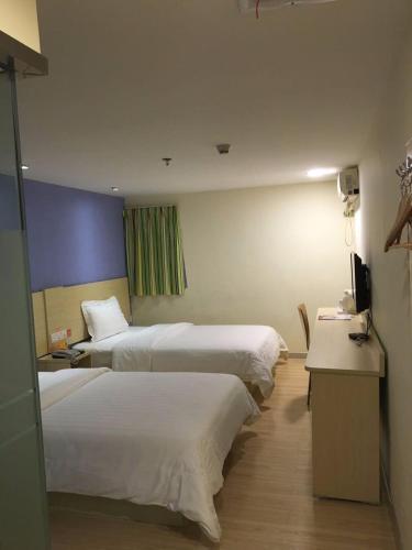 Habitación de hotel con 2 camas y escritorio en 7Days Inn Shenzhen Diwang Building Honggui Road Branch, en Shenzhen