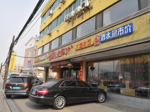 a black car parked in front of a building at 7Days Premium Dalian Airport in Dalian