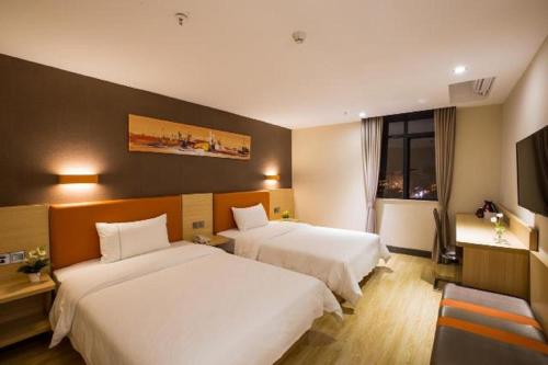 a hotel room with two beds and a flat screen tv at 7Days Premium Tangshan Fengnan Shuang Lake Jinyuan in Tangshan