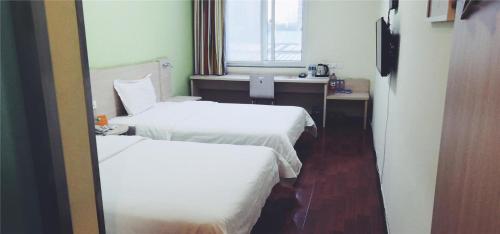 a hotel room with two beds and a mirror at 7Days Inn Tangshan Silicon Valley Digital City in Tangshan