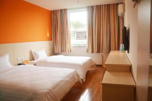 樂山的住宿－7天酒店·峨眉山中心店，酒店客房设有两张床和窗户。