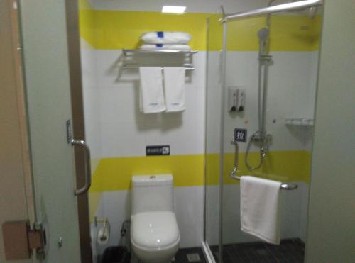 een kleine badkamer met een toilet en een douche bij 7Days Inn Suzhou Wangting Pearl Plaza in Suzhou