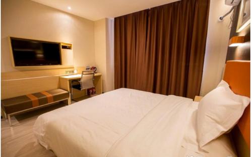 a hotel room with a bed and a television at 7Days Premium Tangshan Fengnan Shuang Lake Jinyuan in Tangshan
