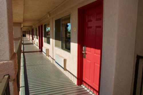 a hallway with red doors on a building at Ramada by Wyndham Yuma in Yuma
