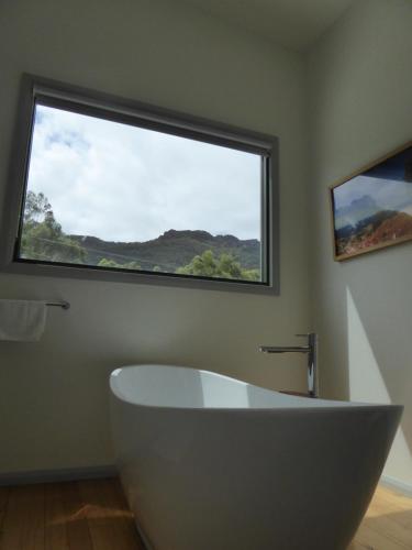 a bath tub in a bathroom with a large window at Dacelo in Halls Gap