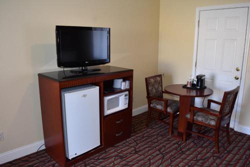 a living room with a tv and a small table at Seaside Inn Monterey in Seaside