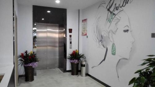 a hallway with flowers in vases on a wall at 7Days Premium Tangshan Fengnan Shuang Lake Jinyuan in Tangshan
