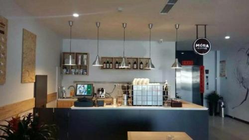 a restaurant with a counter in the middle of a room at 7Days Premium Tangshan Fengnan Shuang Lake Jinyuan in Tangshan