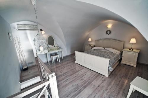 費拉的住宿－Archontiko Suites Santorini，一间卧室配有一张床、一张桌子和一张桌子