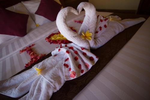 twee handdoeken in de vorm van harten liggen op een bed bij Rijet Villa Beach & Restaurant in Nusa Penida