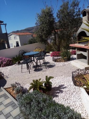 a patio with a table and chairs and flowers at Tomena apartments in Trogir