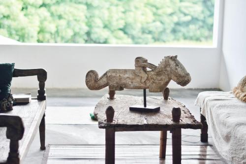 a statue of a horse on a table in a room at Lambo home stay in Waikabubak