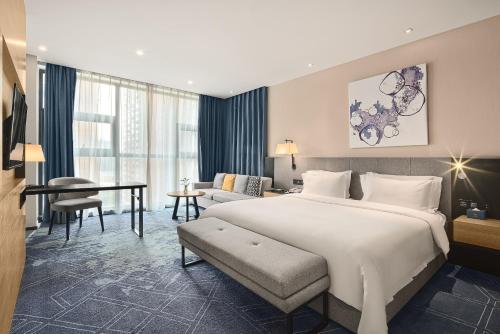 a hotel room with a large bed and a desk at 成都V hotel精品酒店 in Chengdu