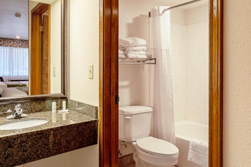 a bathroom with a toilet and a sink and a tub at Quality Inn Three Rivers in Three Rivers