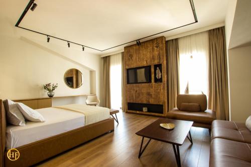 um quarto de hotel com uma cama e um sofá em Hotel Fantasy em Gjirokastër