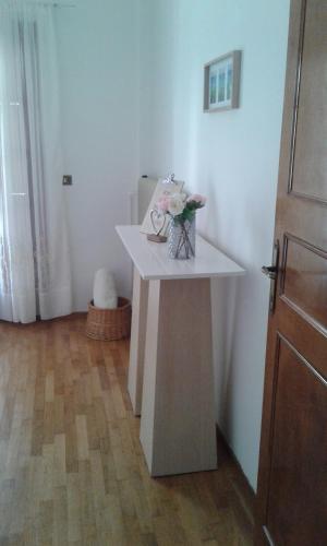 a white table with a vase of flowers on it at OLYMPUS HILL in Litochoro