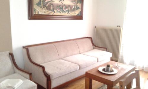 a living room with a white couch and a table at OLYMPUS HILL in Litochoro