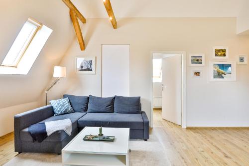 a living room with a blue couch and a table at Apartments am Frankenteich in Stralsund
