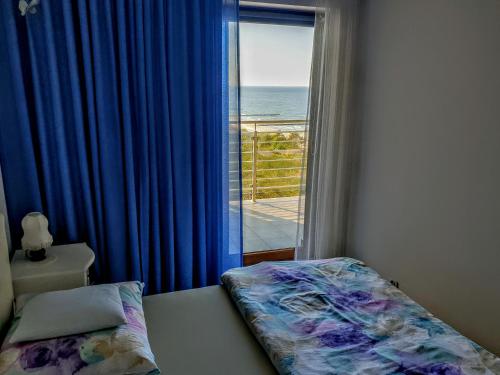 a bedroom with a bed and a view of the ocean at Apartamenty Porta Mare in Dziwnówek