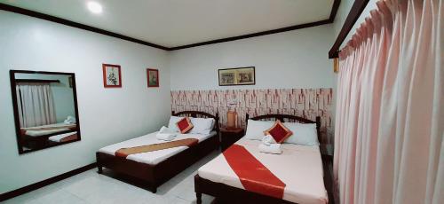 a hotel room with two beds and a mirror at Brazaville Beach Resort in Hinoba-an