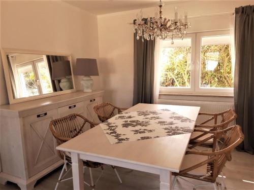 a dining room with a white table and chairs at Ferienhaus "Villa am Eck" in Eichenzell