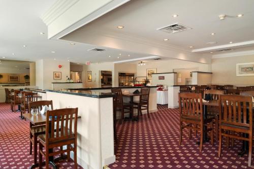 un restaurante con mesas y sillas y un bar en Ramada by Wyndham Trenton, en Trenton